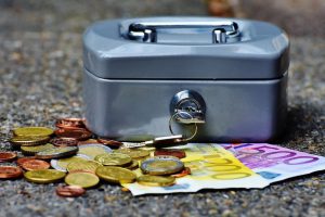 skarbonka i rozsypane banknoty i monety euro